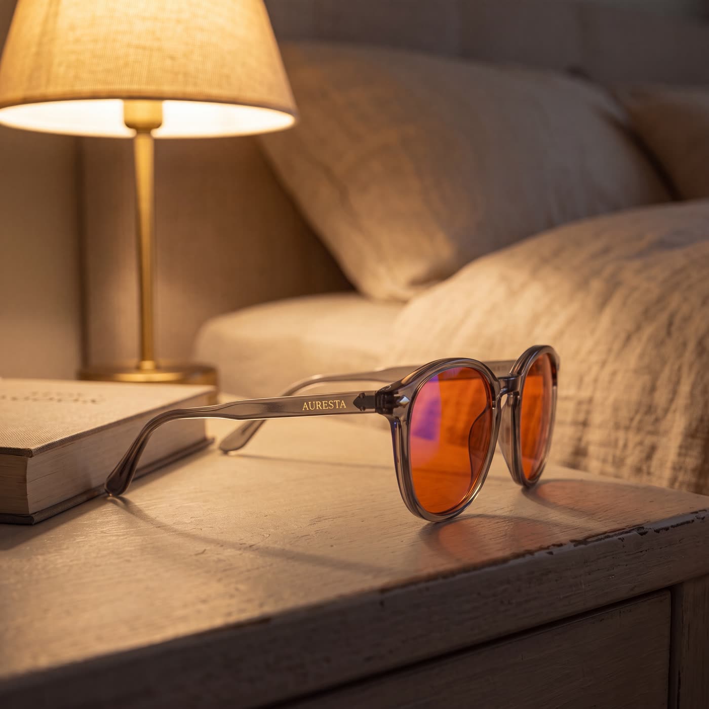 The Aura blue light glasses resting on a bedside table while their owner sleeps